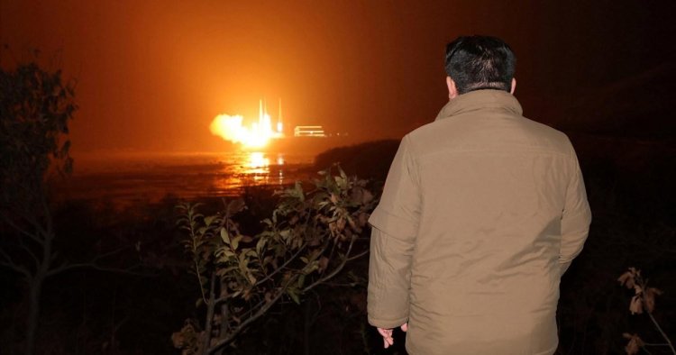 Snuggly, cuddly Kim Jong-un wraps warm to watch his spy satellite being launched